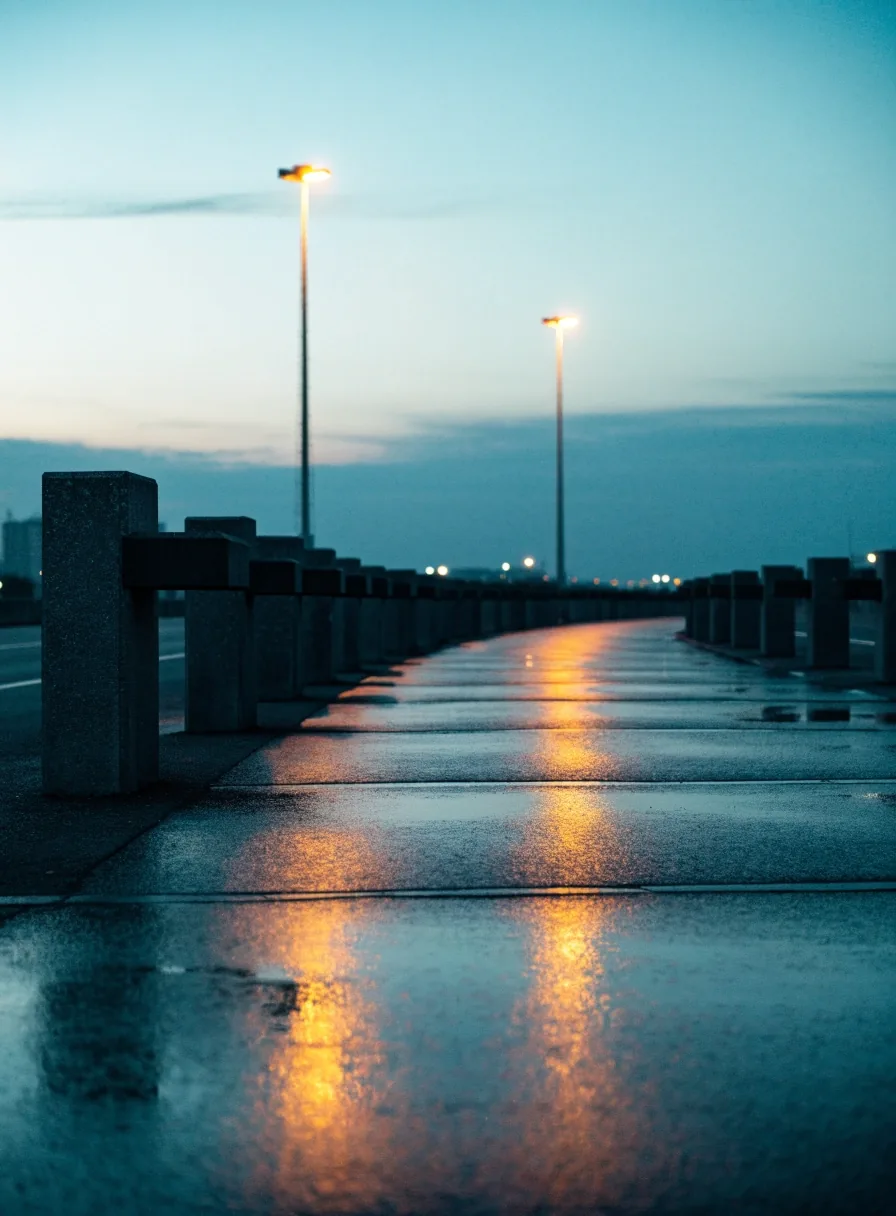 Wheel stops receding along an empty long-stay car park lane at dusk